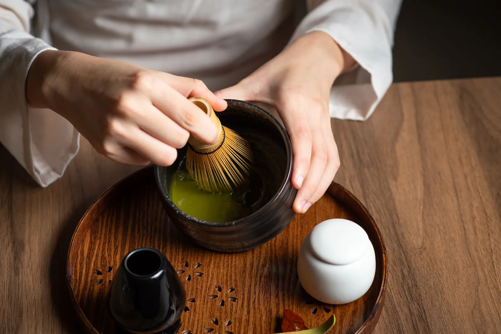 Hands preparing matcha in the traditional way