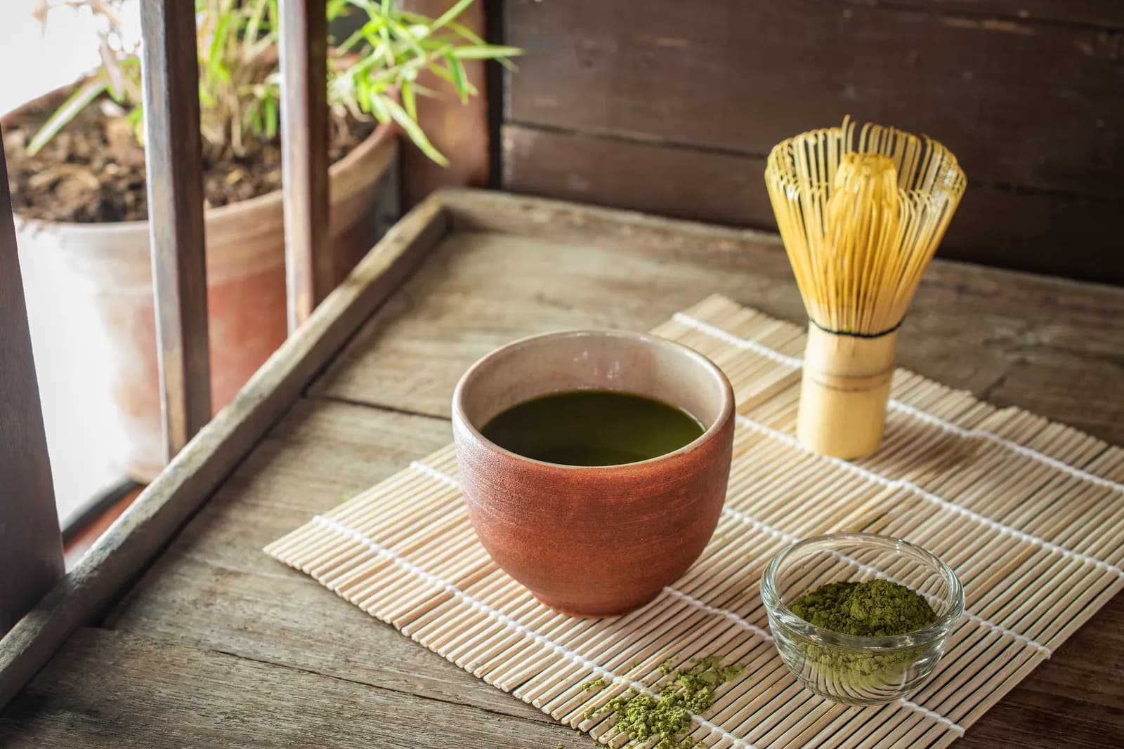 Whisking ceremonial matcha in a black bowl