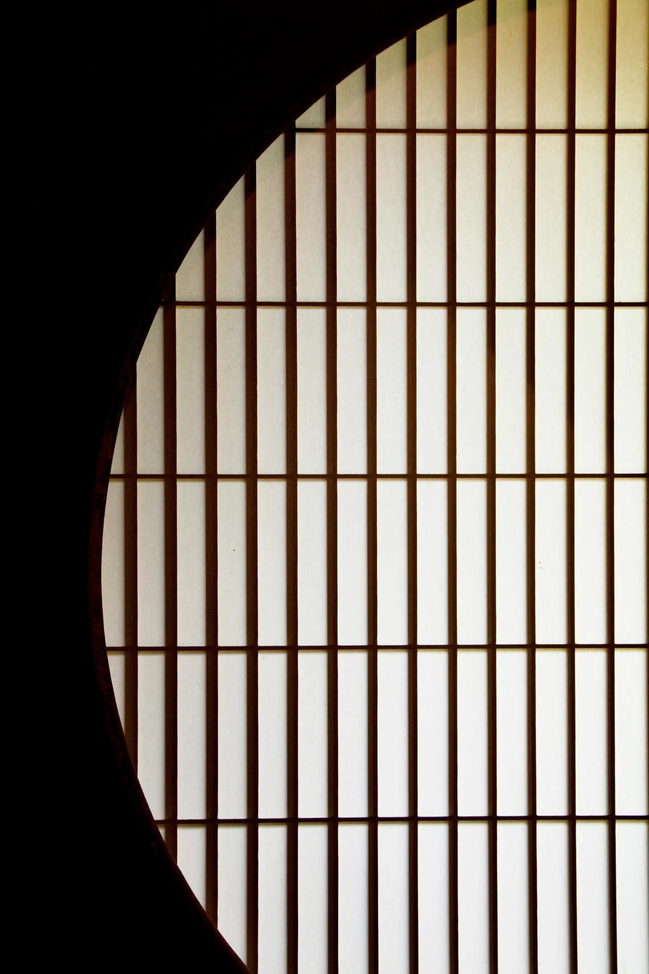 A round window set against a shoji screen in a tea house